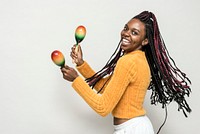 Cheerful black woman enjoying maracas isolated on a gray background