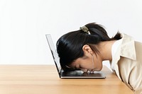 Stressed Asian girl resting her head on a laptop