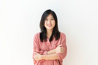 Cheerful woman standing by a white wall