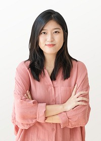 Beautiful cheerful woman standing by a white wall