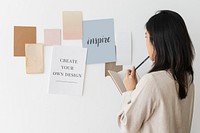 Woman with paper mockups on a wall 