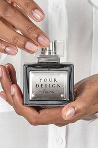 Hands holding blank perfume glass bottle mockup