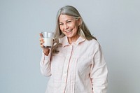 Cheerful senior woman drinking a glass of milk