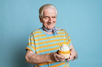 Senior man holding a birthday cupcake 