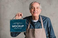 Senior man holding shop sign plate mockup