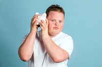 Young man with Down syndrome checking his piggy bank