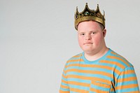 Confident boy with down syndrome wearing a crown 