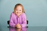 Cute girl with Down Syndrome in a purple sweater