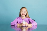 Cute girl with down syndrome holding a glass of milk