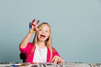 Cute girl with Down Syndrome playing with paints