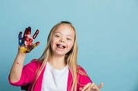 Cute girl with Down Syndrome playing with paints