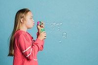 Cute girl with Down Syndrome blowing bubbles