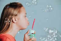 Cute girl with Down Syndrome blowing bubbles