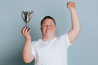 Cute boy with down syndrome holding a trophy 