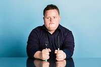 Hungry kid with down syndrome waiting for dinner