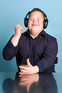 Cool young man with Down Syndrome listening to a sport podcast