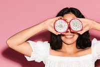 Woman covering her eyes with sliced dragon fruits