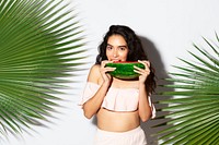 Happy woman biting into a slice of watermelon