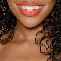 Happy black woman wearing peach lip gloss 