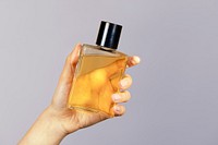 Woman holding an unlabeled perfume glass bottle