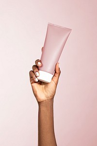 Black woman holding a beauty cream tube 
