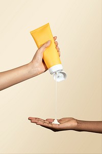 Woman squeezing cream from an unlabeled yellow tube