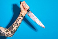 Hand with tattooed holding a knife 
