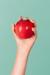 Hand showing a fresh red blush apple