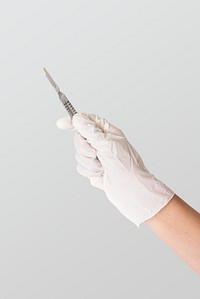 Doctor&#39;s hand in a white glove holding a scalpel