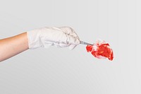 Gloved hand using tweezers to hold a red gauze