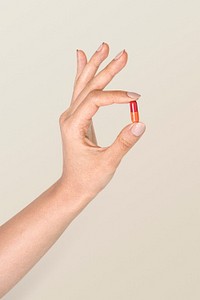 Hand holding a colorful pill mockup