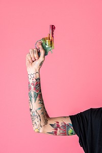 Feminine tattooed hand raising up a rainbow gun