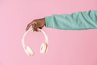 Hand holding a pink headphones