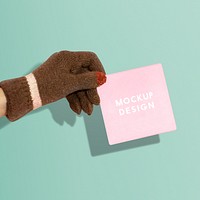 Hand wearing glove holding a paper psd mockup