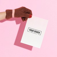 Hand wearing glove holding a paper mockup