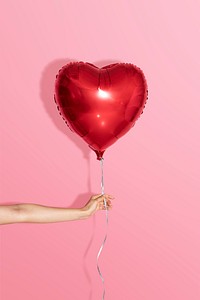 Heart shaped balloon on a pink background
