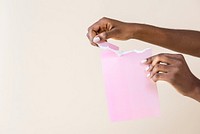 Black woman tearing a blank pink paper 