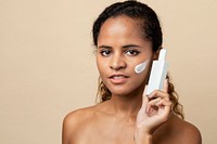 Beautiful African American woman holding a facial cream container for skincare