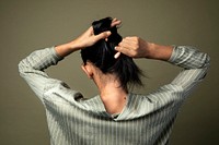Rear view of a woman putting her long hair up