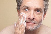 Senior man using facial foam cleanser to wash his face