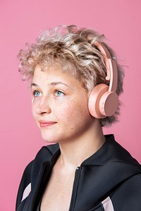 Studio portrait of an active cute blonde girl wearing black hoodie and headphones