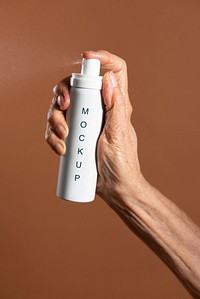 Hand holding a white aerosol spray bottle mockup