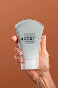 Hand holding a facial cream tube container mockup