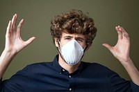 Young Caucasian man wearing a protective mask suffering from air pollution<br /> 