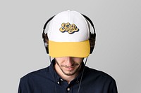 Man with a white cap mockup and headphones on a gray background