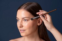 Makeup artist applying color onto a model&#39;s face