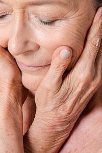 Close up of a senior woman touching her face