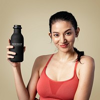 Sporty woman holding a black bottle mockup