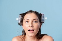 Young woman using hair curlers 