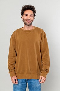 Cheerful man in brown sweater and blue jeans